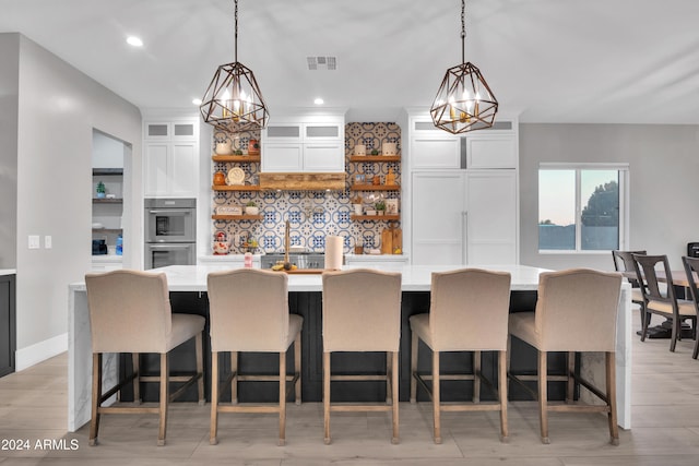 kitchen with a breakfast bar, white cabinetry, glass insert cabinets, and open shelves