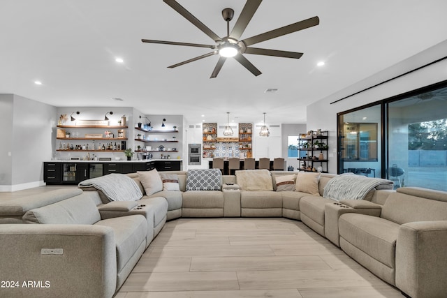 living area featuring ceiling fan, light wood-style floors, recessed lighting, and wet bar