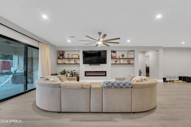 living room with light wood-style floors, a glass covered fireplace, a ceiling fan, and recessed lighting