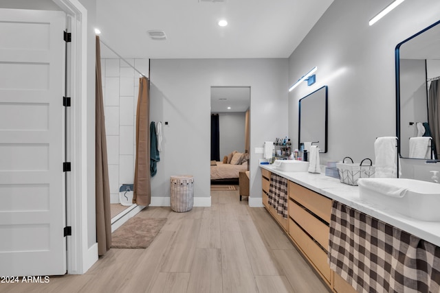 ensuite bathroom featuring a shower with curtain, ensuite bath, visible vents, and wood finished floors