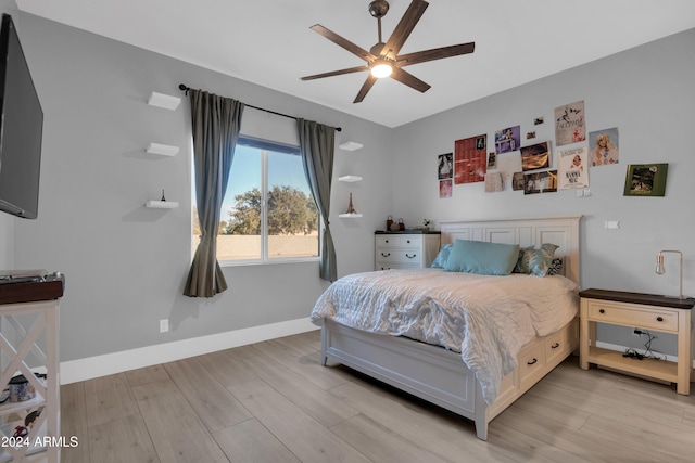 bedroom featuring a ceiling fan, baseboards, and light wood finished floors