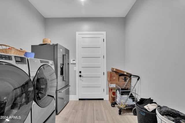 washroom with light wood-style floors, washer and dryer, laundry area, and baseboards