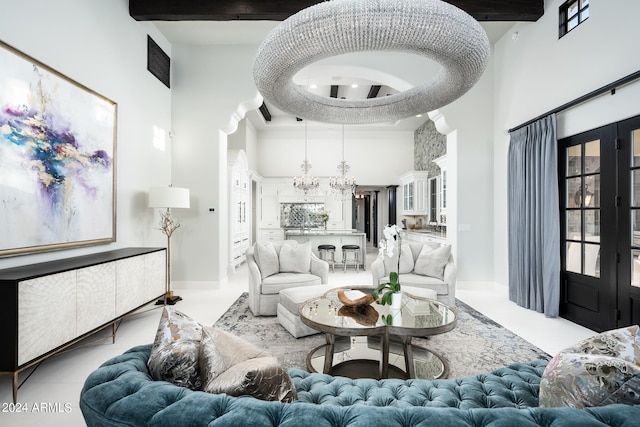 living room with a notable chandelier, french doors, light tile patterned flooring, and a high ceiling