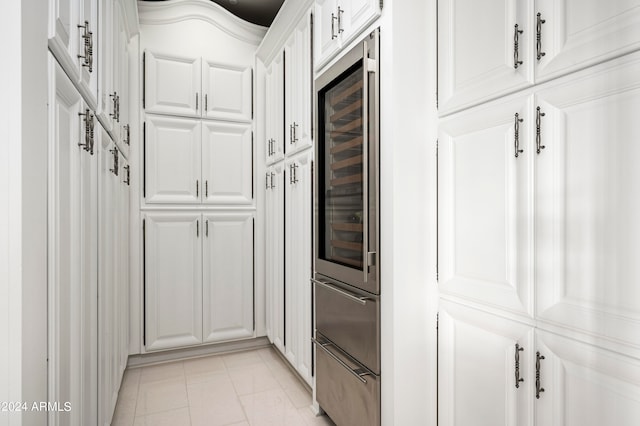 kitchen with white cabinets, light tile patterned floors, and wine cooler