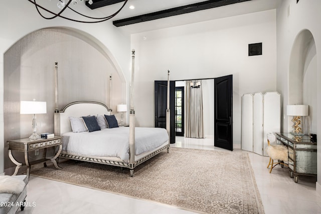 bedroom with a high ceiling and beam ceiling