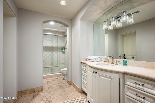 bathroom featuring toilet, a shower with door, and vanity