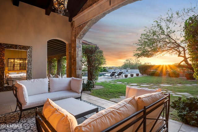 patio terrace at dusk with an outdoor living space and a yard