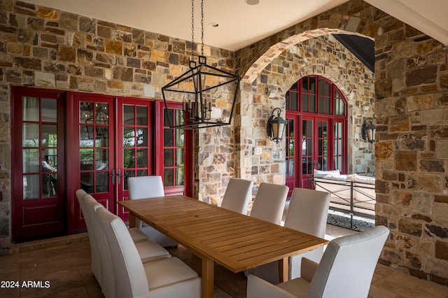 dining space featuring vaulted ceiling, a notable chandelier, and french doors