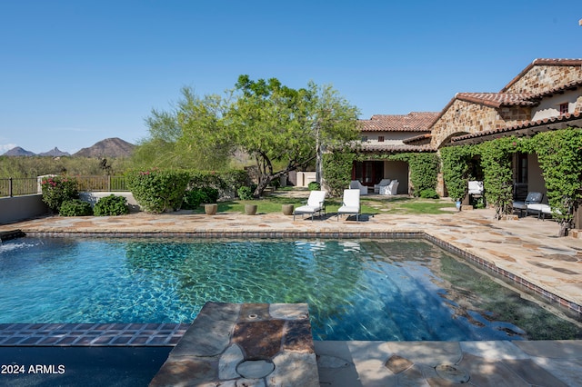 view of swimming pool with a mountain view and a patio area