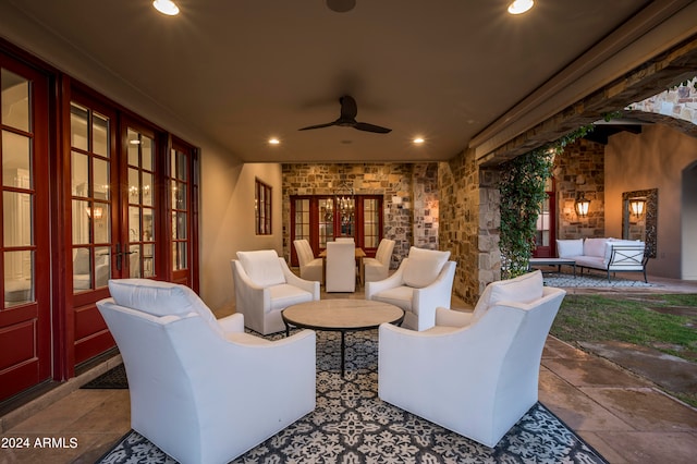 view of patio / terrace featuring an outdoor living space with a fireplace, ceiling fan, and french doors