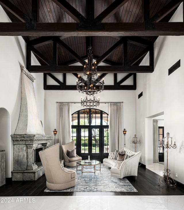 living room with a fireplace, high vaulted ceiling, beam ceiling, and a notable chandelier