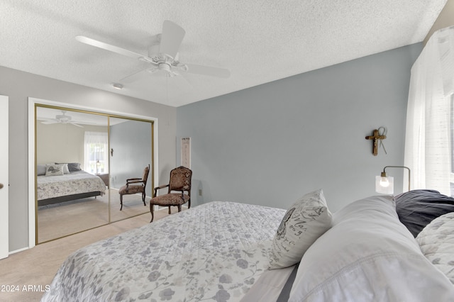 carpeted bedroom featuring a closet, a textured ceiling, and ceiling fan