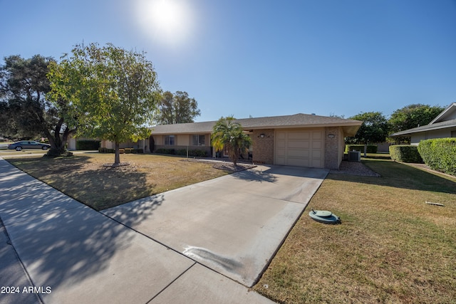 ranch-style home with a front yard, a garage, and central AC