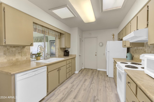 kitchen with light wood-type flooring, white appliances, and tasteful backsplash