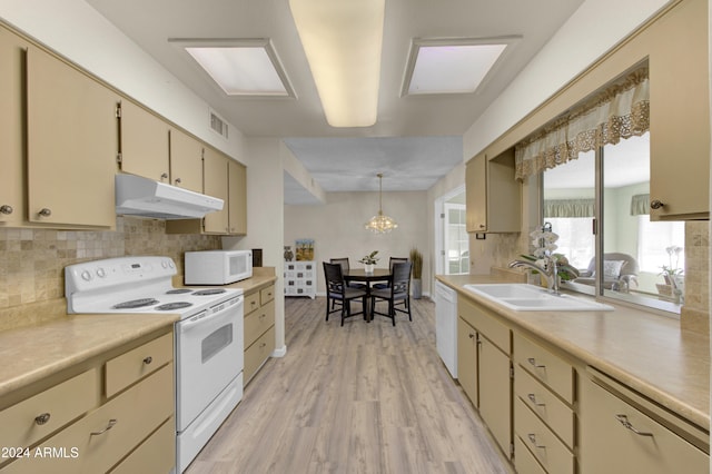 kitchen with light wood-type flooring, white appliances, decorative light fixtures, sink, and decorative backsplash