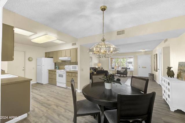 dining room with an inviting chandelier, hardwood / wood-style flooring, and a textured ceiling