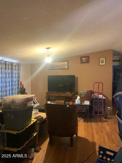 living room featuring a textured ceiling and wood finished floors