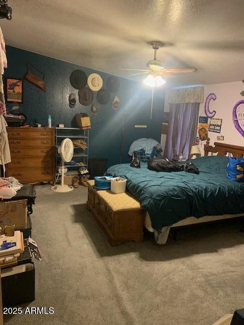 bedroom featuring carpet floors, a ceiling fan, and a textured ceiling