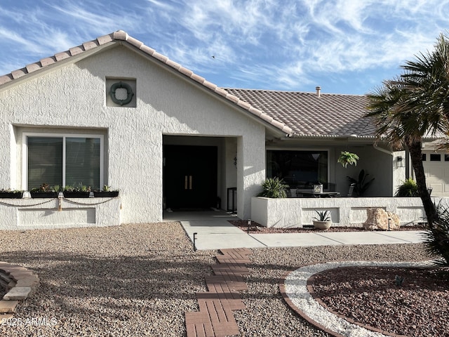 exterior space featuring a tiled roof and stucco siding