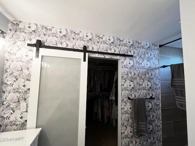 bathroom featuring a walk in closet and tiled shower