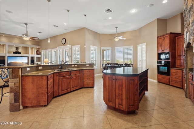 kitchen with a large island, black appliances, light tile patterned floors, and sink