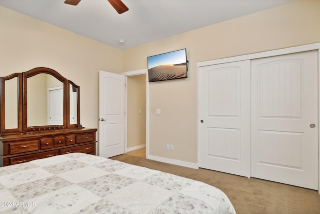 unfurnished bedroom featuring light carpet, a closet, and ceiling fan