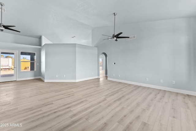 unfurnished living room with arched walkways, visible vents, ceiling fan, and light wood-style flooring