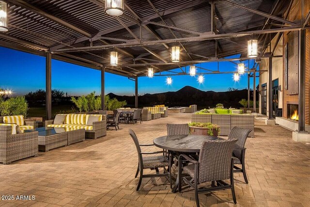 patio terrace at dusk with outdoor lounge area and a mountain view