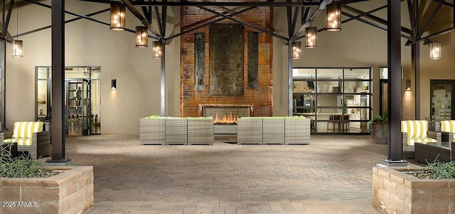 unfurnished living room with a towering ceiling and a brick fireplace