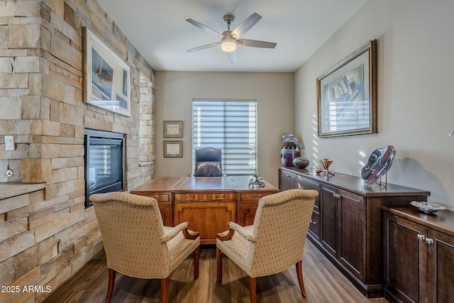 office space with a fireplace, light hardwood / wood-style flooring, and ceiling fan