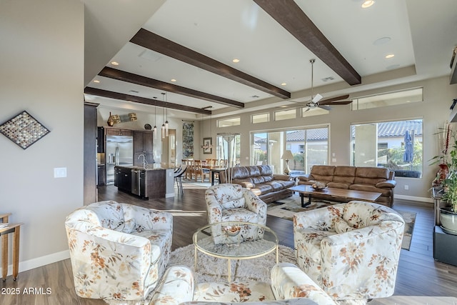 living room featuring ceiling fan, dark hardwood / wood-style flooring, beamed ceiling, and sink