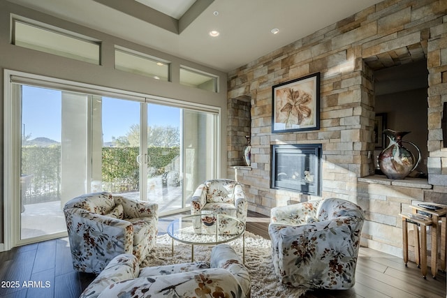 living room featuring a stone fireplace and hardwood / wood-style flooring