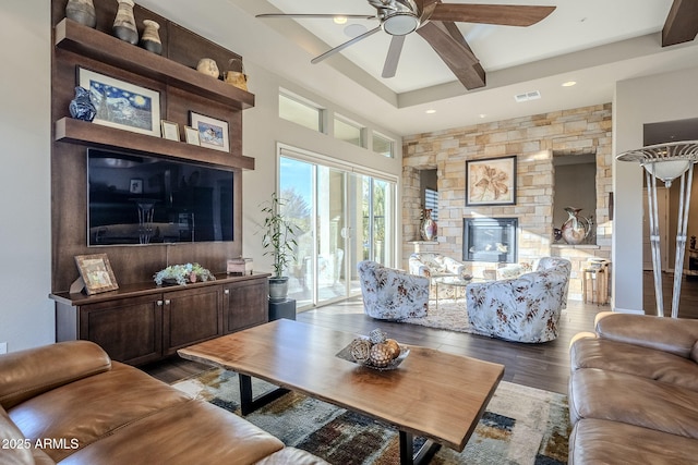 living room featuring ceiling fan, dark hardwood / wood-style flooring, and a fireplace