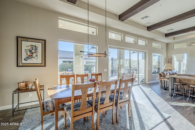 dining room featuring beam ceiling and dark hardwood / wood-style flooring