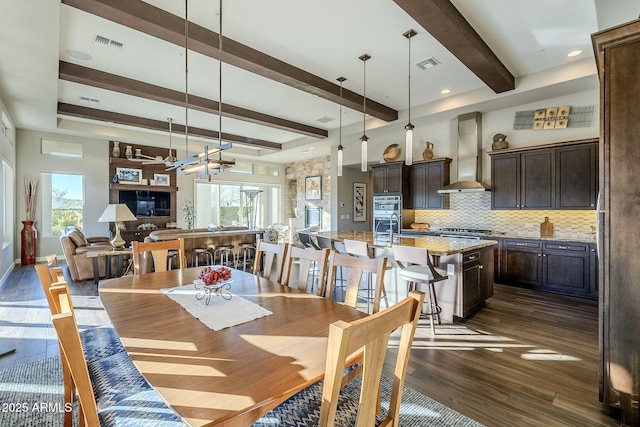 dining space featuring dark hardwood / wood-style flooring and beamed ceiling