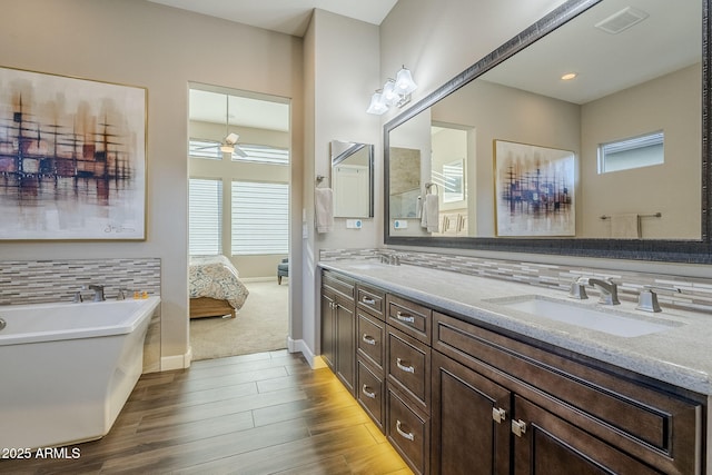 bathroom with vanity, a tub, ceiling fan, and a healthy amount of sunlight