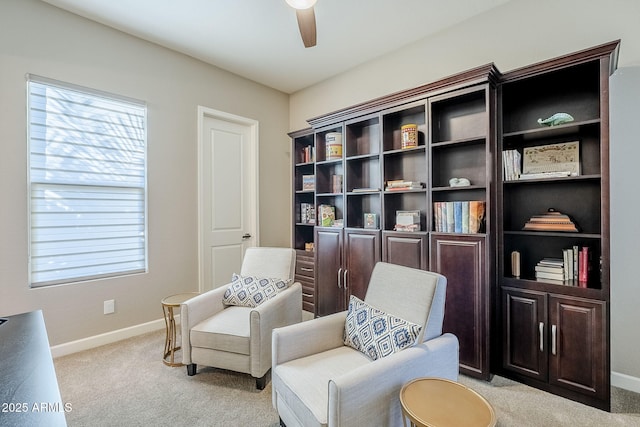 living area featuring ceiling fan, a healthy amount of sunlight, and light colored carpet