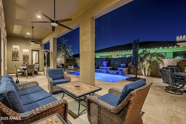 patio at twilight with a fenced in pool, pool water feature, and ceiling fan