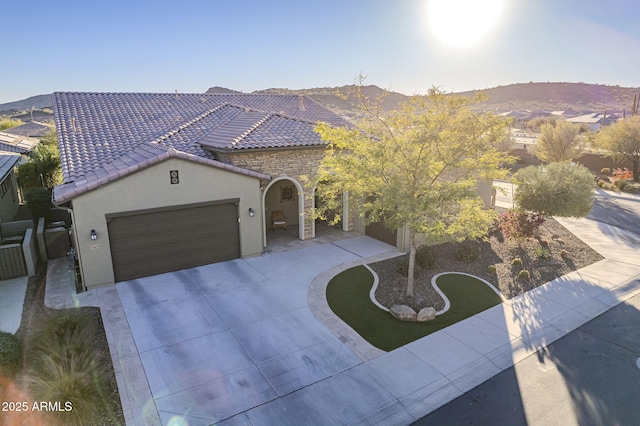 mediterranean / spanish home with a mountain view, a front yard, and a garage