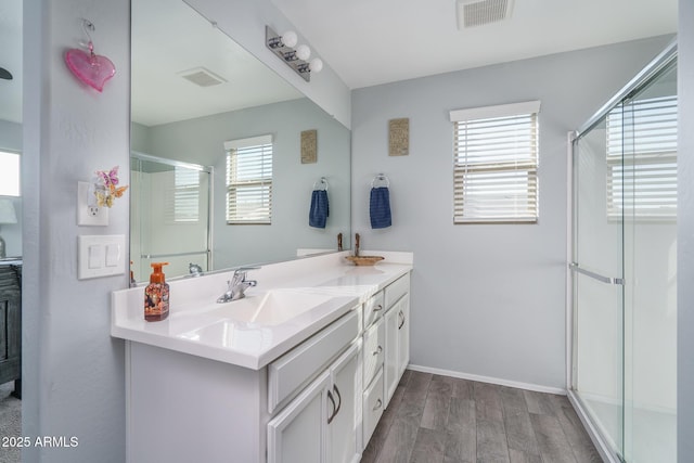 bathroom featuring hardwood / wood-style floors, vanity, and a shower with shower door