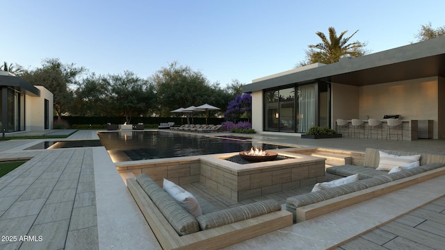 outdoor pool with an outdoor living space with a fire pit and a patio area