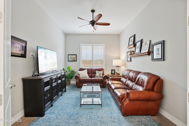 carpeted living area featuring baseboards and a ceiling fan