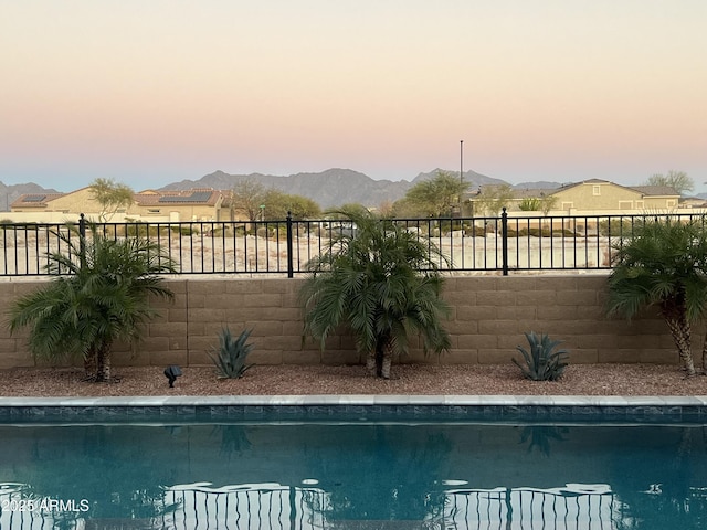 view of pool with a fenced in pool, a mountain view, and fence