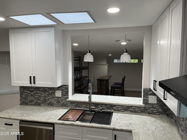 kitchen featuring recessed lighting, decorative backsplash, stainless steel dishwasher, white cabinets, and a sink