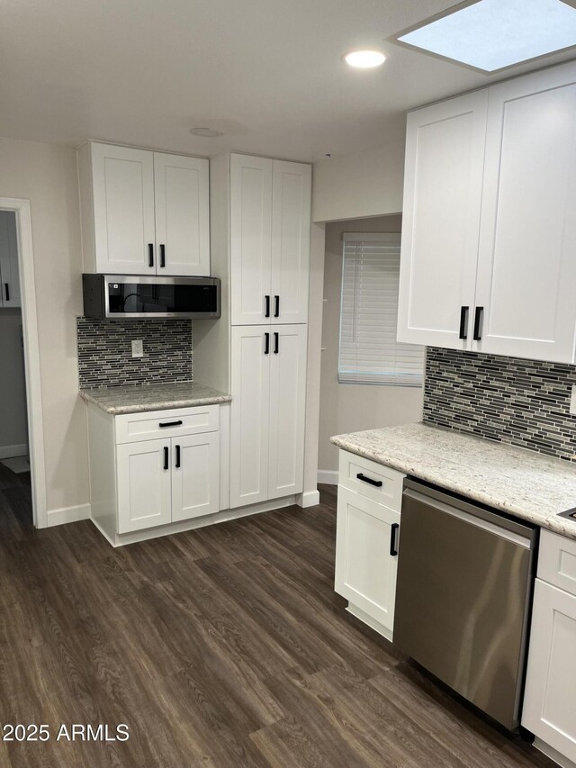 kitchen with appliances with stainless steel finishes, dark wood-type flooring, and white cabinetry