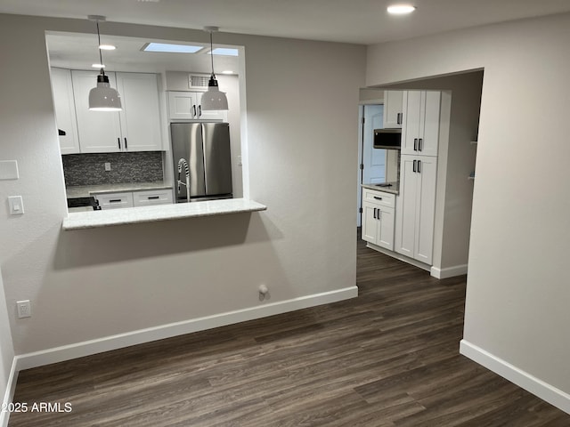 kitchen featuring dark wood-style flooring, white cabinetry, baseboards, appliances with stainless steel finishes, and decorative backsplash