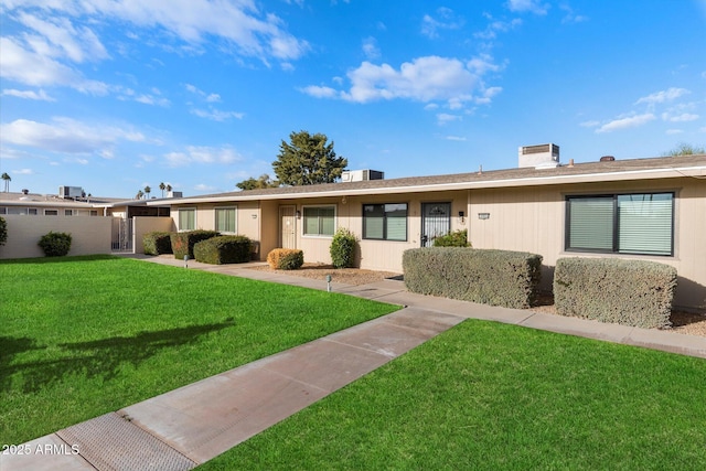 ranch-style house featuring fence and a front lawn