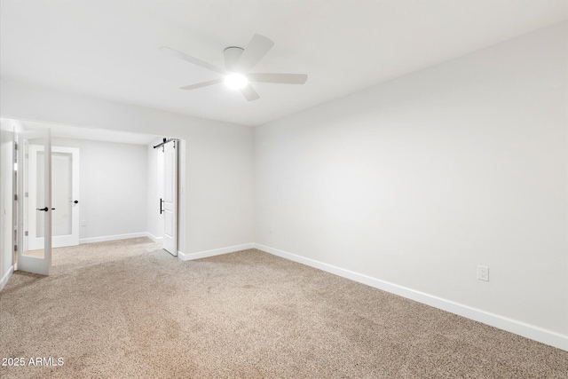 unfurnished room featuring light carpet, baseboards, and a ceiling fan