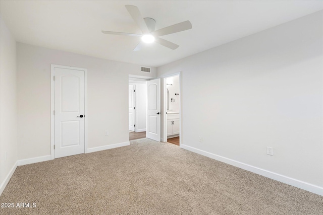 unfurnished bedroom with visible vents, baseboards, ensuite bath, ceiling fan, and carpet