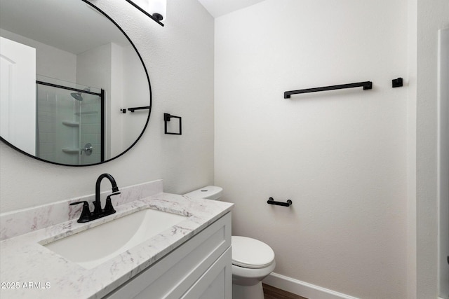 bathroom featuring tiled shower, vanity, toilet, and baseboards